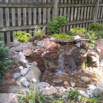 Shady Backyard with Waterfall, Stream, Fireplace and Landscape