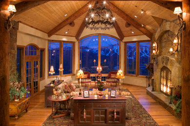 Mid-sized mountain style formal and open concept medium tone wood floor living room photo in Denver with beige walls, a standard fireplace, a stone fireplace and no tv