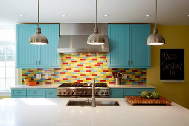 Example of an eclectic medium tone wood floor kitchen design in Chicago with an undermount sink, blue cabinets, multicolored backsplash, ceramic backsplash, stainless steel appliances and an island