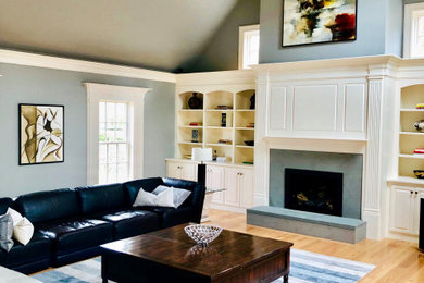 Inspiration for a mid-sized contemporary light wood floor family room library remodel in Boston with gray walls and a corner tv