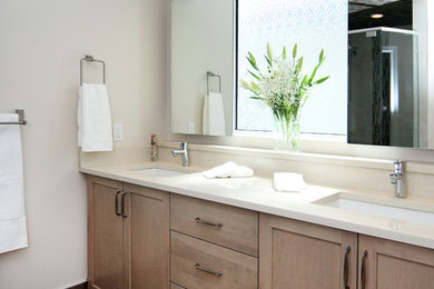 Example of a small transitional master porcelain tile slate floor corner shower design in Calgary with an undermount sink, recessed-panel cabinets, light wood cabinets, solid surface countertops, white walls and a two-piece toilet