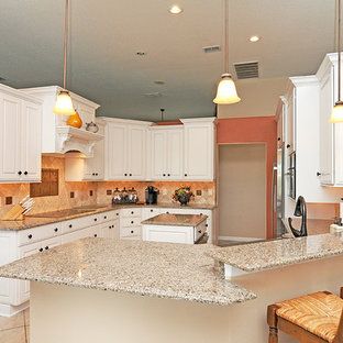 Mid-sized traditional kitchen pantry designs - Kitchen pantry - mid-sized traditional u-shaped dark wood floor kitchen pantry idea in Orlando with a farmhouse sink, raised-panel cabinets, white cabinets, solid surface countertops, multicolored backsplash, stone tile backsplash, stainless steel appliances and an island