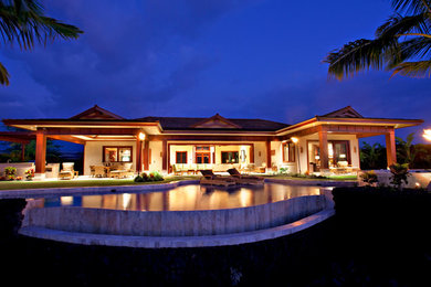 Large arts and crafts backyard stone and custom-shaped infinity pool fountain photo in Hawaii