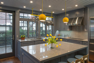 Example of a large trendy u-shaped medium tone wood floor kitchen design in New York with recessed-panel cabinets, quartz countertops, an island, an undermount sink and green cabinets
