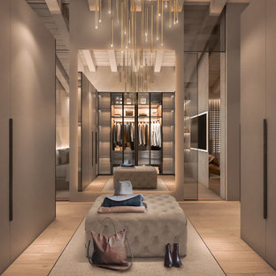 Bild på ett mycket stort funkis walk-in-closet, med luckor med glaspanel, skåp i ljust trä och ljust trägolv
