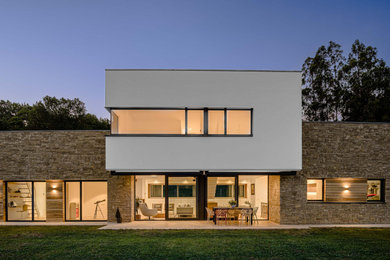 Modelo de fachada de casa contemporánea de dos plantas con revestimiento de piedra