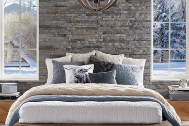 Example of a mid-sized trendy master medium tone wood floor bedroom design in Houston with gray walls and no fireplace