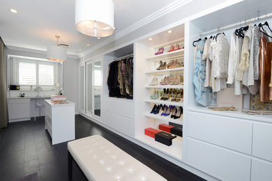 Photo of a large contemporary women's walk-in wardrobe in Sydney with white cabinets and porcelain floors.
