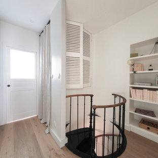 Foto di una scala a chiocciola nordica di medie dimensioni con pedata in legno verniciato, alzata in legno verniciato e parapetto in metallo