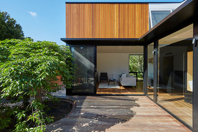 Small contemporary one-storey exterior in Melbourne with wood siding.