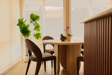 This is an example of a large modern kitchen/dining combo in Adelaide with beige walls, laminate floors, beige floor and timber.