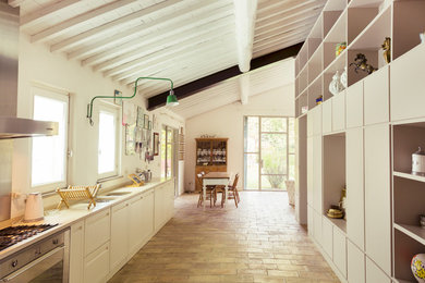 Photo of a country single-wall kitchen in Other with flat-panel cabinets and stainless steel appliances.