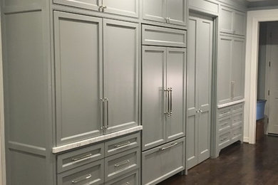 Open concept kitchen - large traditional l-shaped dark wood floor open concept kitchen idea in Houston with an undermount sink, shaker cabinets, blue cabinets, wood countertops, gray backsplash, stone slab backsplash, paneled appliances and an island