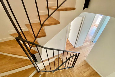 Aménagement d'un escalier peint contemporain en U de taille moyenne avec des marches en bois et un garde-corps en métal.