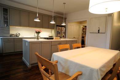 Inspiration for a mid-sized transitional galley dark wood floor eat-in kitchen remodel in New York with an undermount sink, shaker cabinets, gray cabinets, quartzite countertops, white backsplash, stone slab backsplash, stainless steel appliances and an island