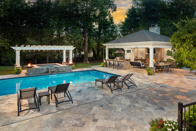 Foto de piscina clásica renovada grande en patio trasero con adoquines de piedra natural