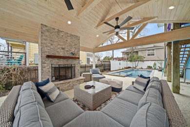 Inspiration for a back patio in Houston with a fireplace and a roof extension.