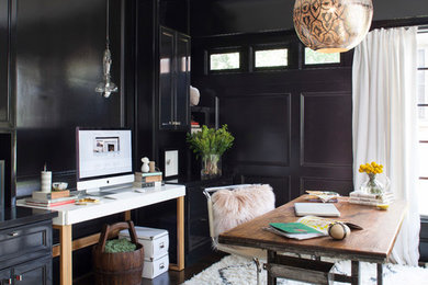 This is an example of a mid-sized transitional study room in Atlanta with black walls, dark hardwood floors and a freestanding desk.