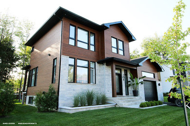 Inspiration for a contemporary two-storey brown house exterior in Montreal with wood siding.