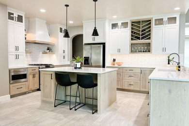 Large minimalist u-shaped porcelain tile and gray floor open concept kitchen photo with an undermount sink, shaker cabinets, light wood cabinets, quartz countertops, white backsplash, ceramic backsplash, stainless steel appliances, an island and white countertops