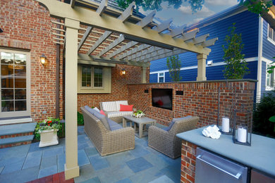 Mid-sized transitional backyard stone patio kitchen photo in Chicago with a pergola