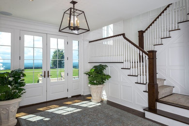 Inspiration for an expansive transitional foyer in Other with white walls, dark hardwood floors, a double front door, a white front door and brown floor.