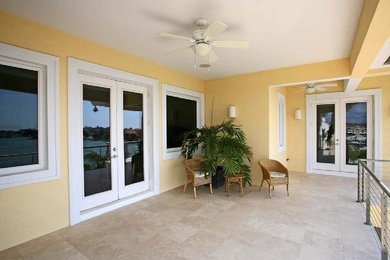 Island style tile back porch idea in Tampa with a roof extension