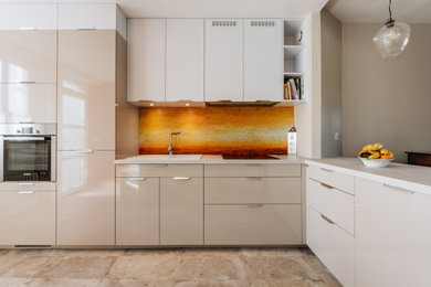 This is an example of a mid-sized contemporary l-shaped open plan kitchen in Paris with an undermount sink, beaded inset cabinets, beige cabinets, orange splashback, stainless steel appliances, ceramic floors and beige floor.