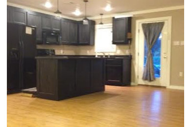 Inspiration for a rustic kitchen remodel in Other with beaded inset cabinets, distressed cabinets, black appliances and an island