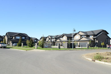 Example of a large classic beige two-story stucco gable roof design in Other