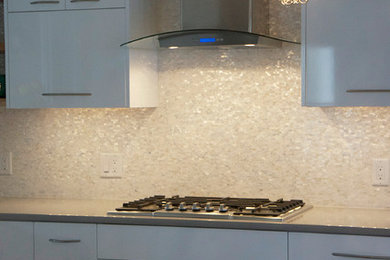 Example of a mid-sized trendy l-shaped dark wood floor eat-in kitchen design in Boston with an undermount sink, flat-panel cabinets, white cabinets, quartz countertops, white backsplash, stainless steel appliances and an island