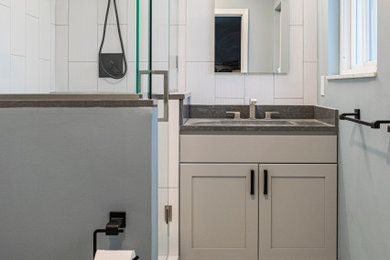 Example of a mid-sized transitional master white tile and ceramic tile ceramic tile, gray floor and single-sink bathroom design in Detroit with recessed-panel cabinets, beige cabinets, a two-piece toilet, an undermount sink, quartz countertops, gray countertops, a niche, a built-in vanity and blue walls
