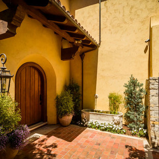 Inspiration för stora medelhavsstil gula hus, med två våningar, stuckatur och tak med takplattor