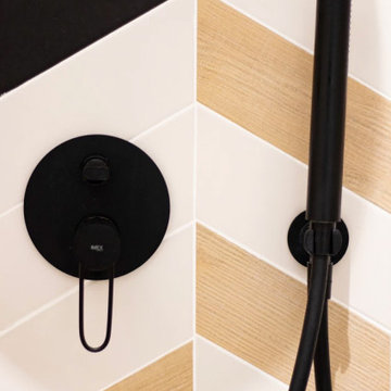 Zoom sur la faïence et la robinetterie noire de la douche