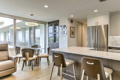 Inspiration for a small modern galley light wood floor and brown floor eat-in kitchen remodel in Omaha with an undermount sink, flat-panel cabinets, medium tone wood cabinets, quartz countertops, white backsplash, marble backsplash, stainless steel appliances and no island