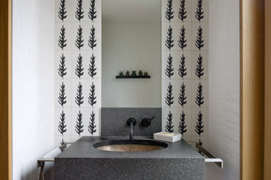 Example of a minimalist black and white tile and ceramic tile concrete floor and gray floor powder room design in Seattle with gray cabinets, white walls, an undermount sink, gray countertops and a floating vanity