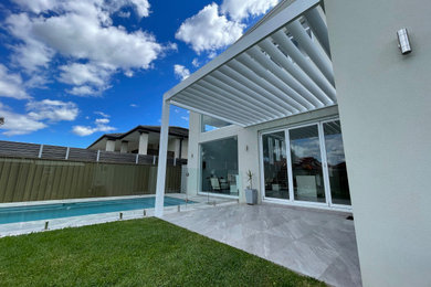 Photo of a mid-sized modern backyard patio in Sydney with a pergola.