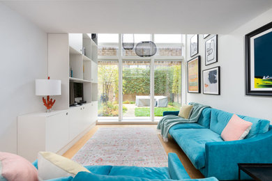 Foto de salón abierto minimalista de tamaño medio con paredes blancas y suelo de madera en tonos medios