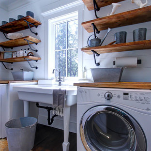 アトランタのカントリー風おしゃれな洗濯室 (スロップシンク、シェーカースタイル扉のキャビネット、白いキャビネット、木材カウンター、白い壁、濃色無垢フローリング、茶色いキッチンカウンター) の写真