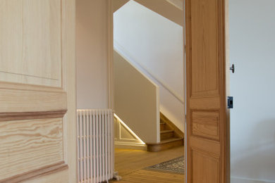 Inspiration pour un grand escalier design en U avec des marches en bois, des contremarches en bois, un garde-corps en matériaux mixtes et éclairage.