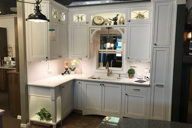 Eat-in kitchen - small cottage l-shaped porcelain tile and brown floor eat-in kitchen idea in Other with a single-bowl sink, shaker cabinets, white cabinets, quartz countertops, white backsplash, subway tile backsplash, white appliances and no island