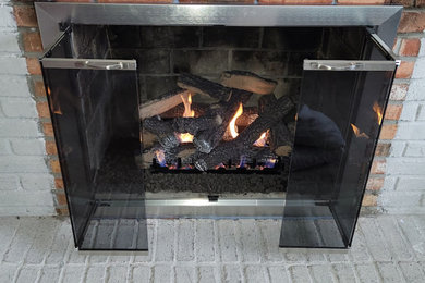 Inspiration for a mid-sized enclosed brick floor and white floor living room remodel in Detroit with a standard fireplace and a brick fireplace