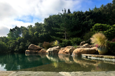 Inspiration for a large rustic backyard tile and custom-shaped infinity pool fountain remodel in San Francisco