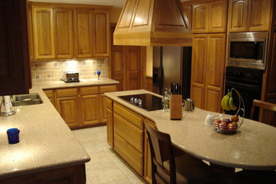 Mid-sized transitional l-shaped ceramic tile eat-in kitchen photo in Houston with a double-bowl sink, raised-panel cabinets, light wood cabinets, solid surface countertops, multicolored backsplash, subway tile backsplash, stainless steel appliances and an island