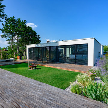 Moderner Seegarten mit großzügiger Holzterrasse