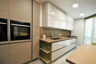 Modelo de cocina moderna con armarios con paneles lisos y una isla