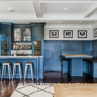 Elegant dark wood floor seated home bar photo in New York with glass-front cabinets, blue cabinets, metal backsplash and white countertops