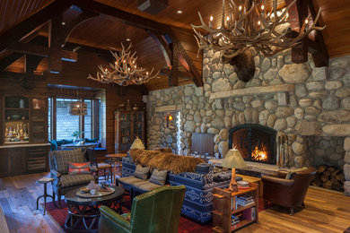 Living room - huge rustic open concept medium tone wood floor living room idea in Grand Rapids with a bar and a standard fireplace