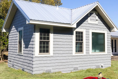 Inspiration for a large contemporary blue one-story vinyl and shingle exterior home remodel in Other with a metal roof and a gray roof