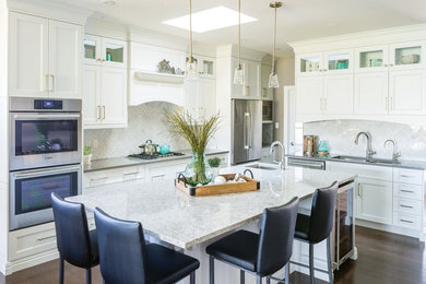 Transitional dark wood floor and brown floor kitchen photo in Toronto with shaker cabinets, white cabinets, an island, a double-bowl sink, white backsplash and stainless steel appliances